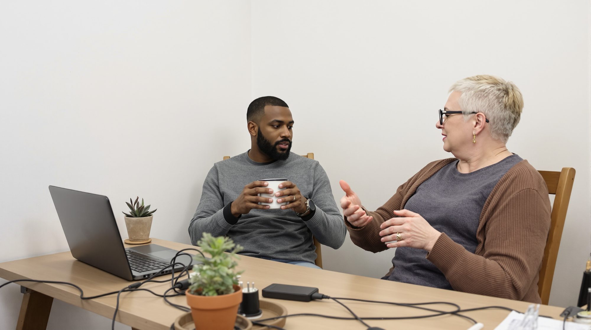 A web designer sitting back and listening while a business owner explains what she needs